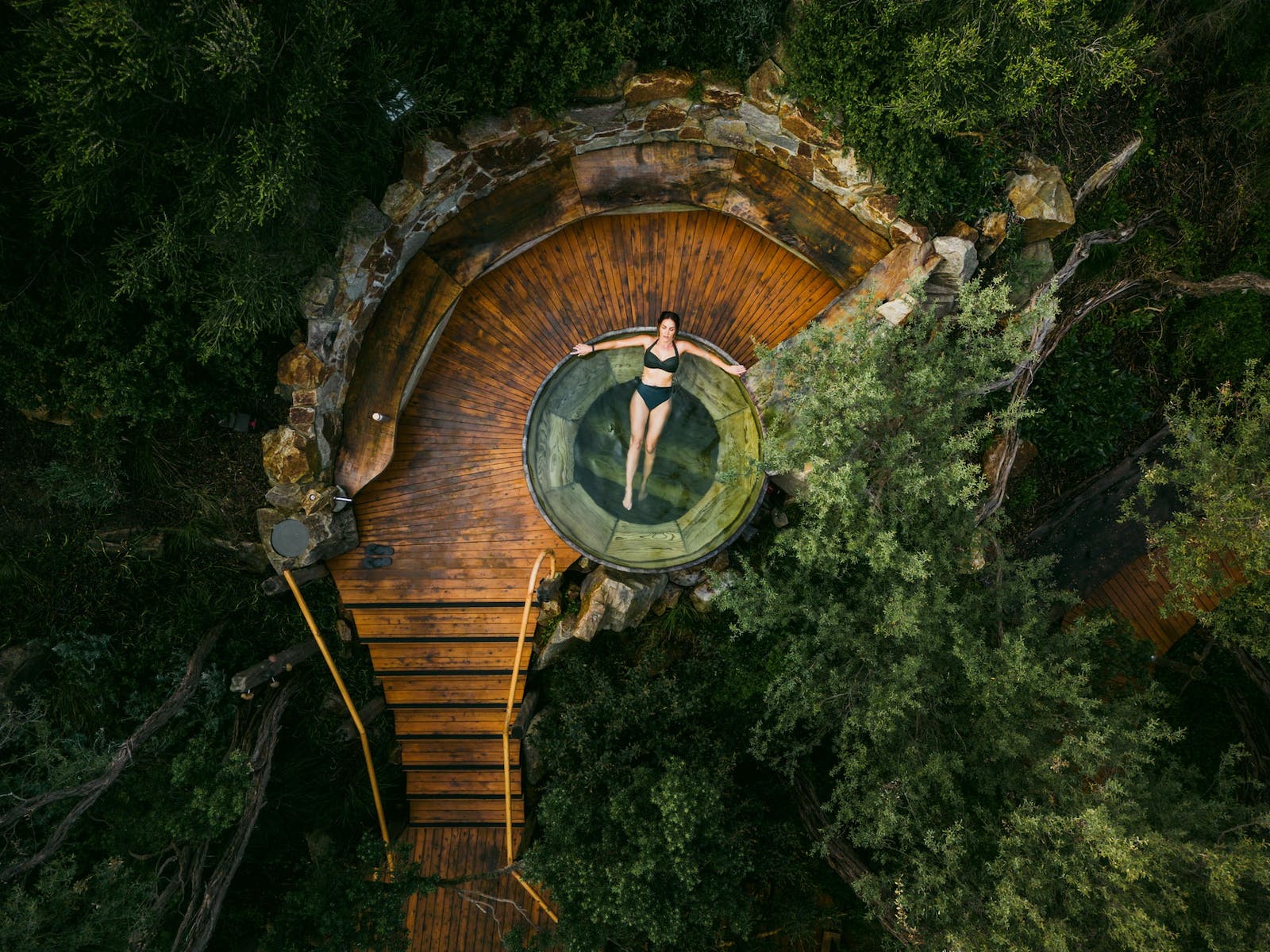Woman laying back in a circular hot spring
